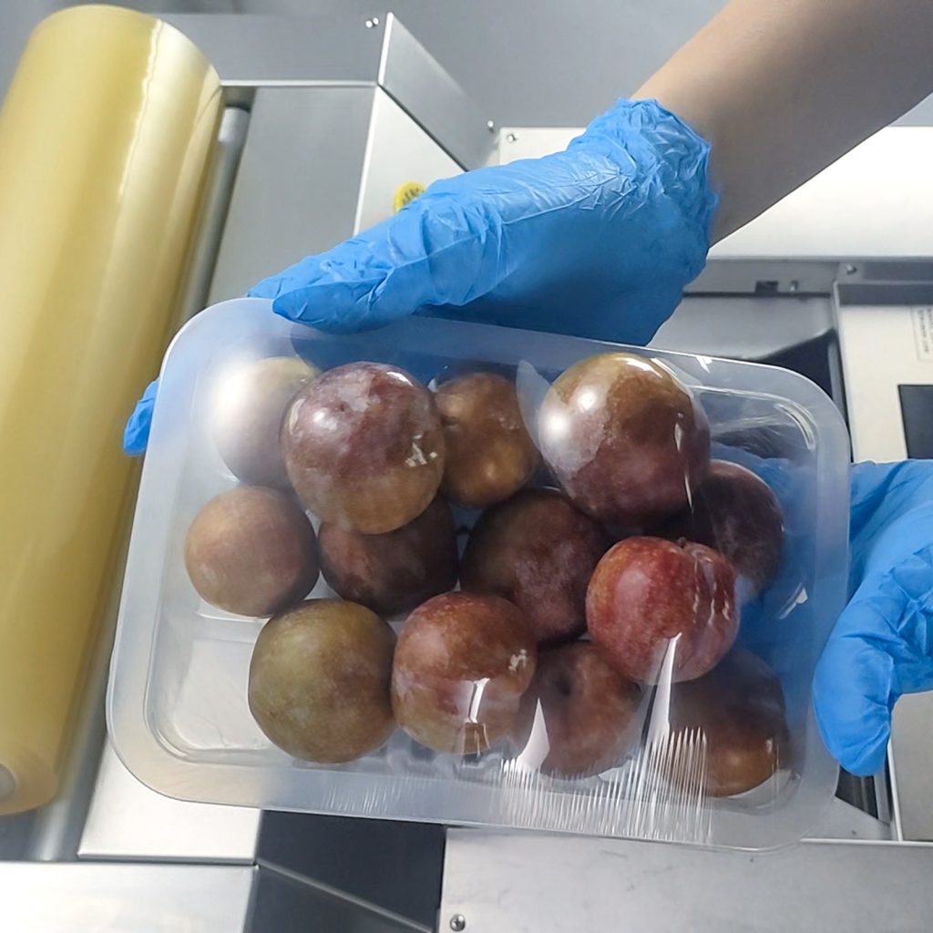 Wrapped produce removed from an automatic cling film machine