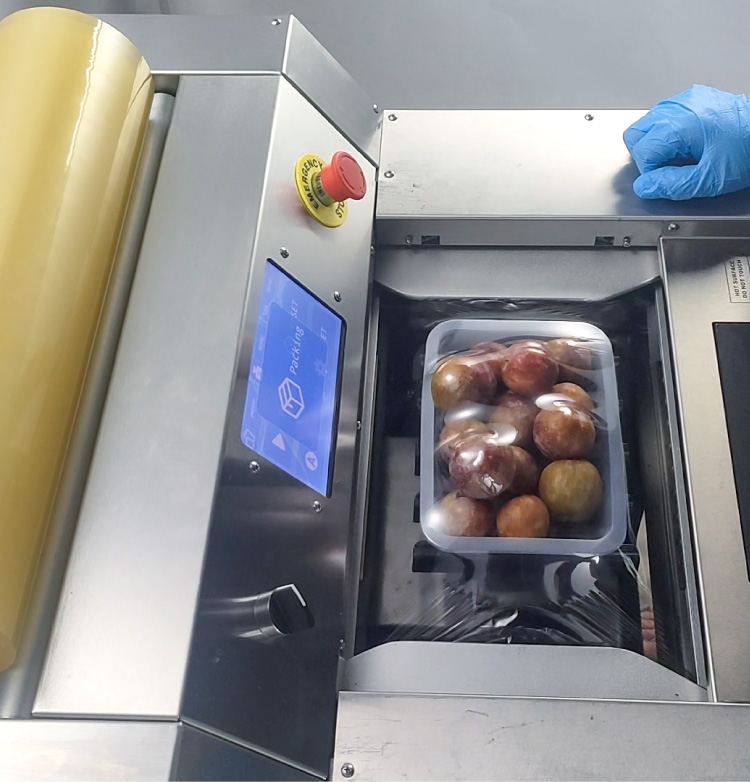 Produce being wrapped by an automatic cling film machine